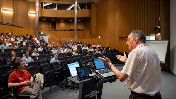 Prof. Frans Spaepen talking to the audience, photographer standing behind the professor
