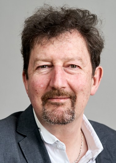 Portrait fo a caucasian man with beard and short brown curly hair