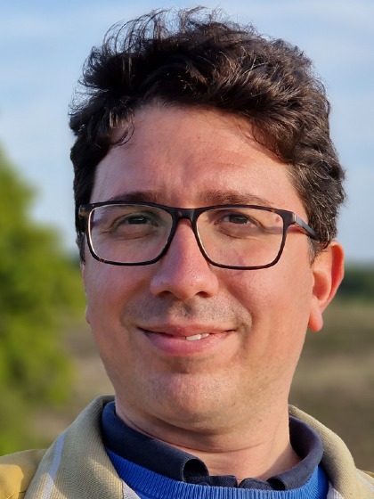 Portrait of a caucasian man with glasses and curly brown hair