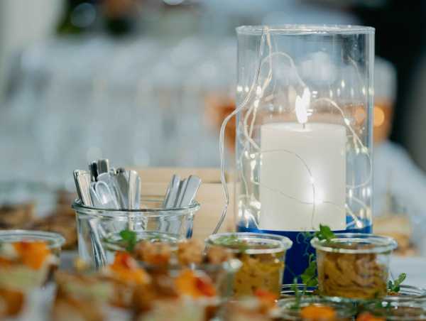 Apero symbolic picture (a candle, spoons and glasses filled with food)