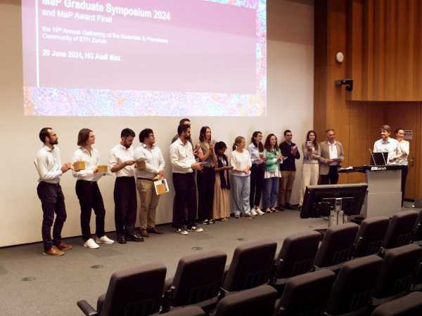 About 12 people lined up in front of a screen