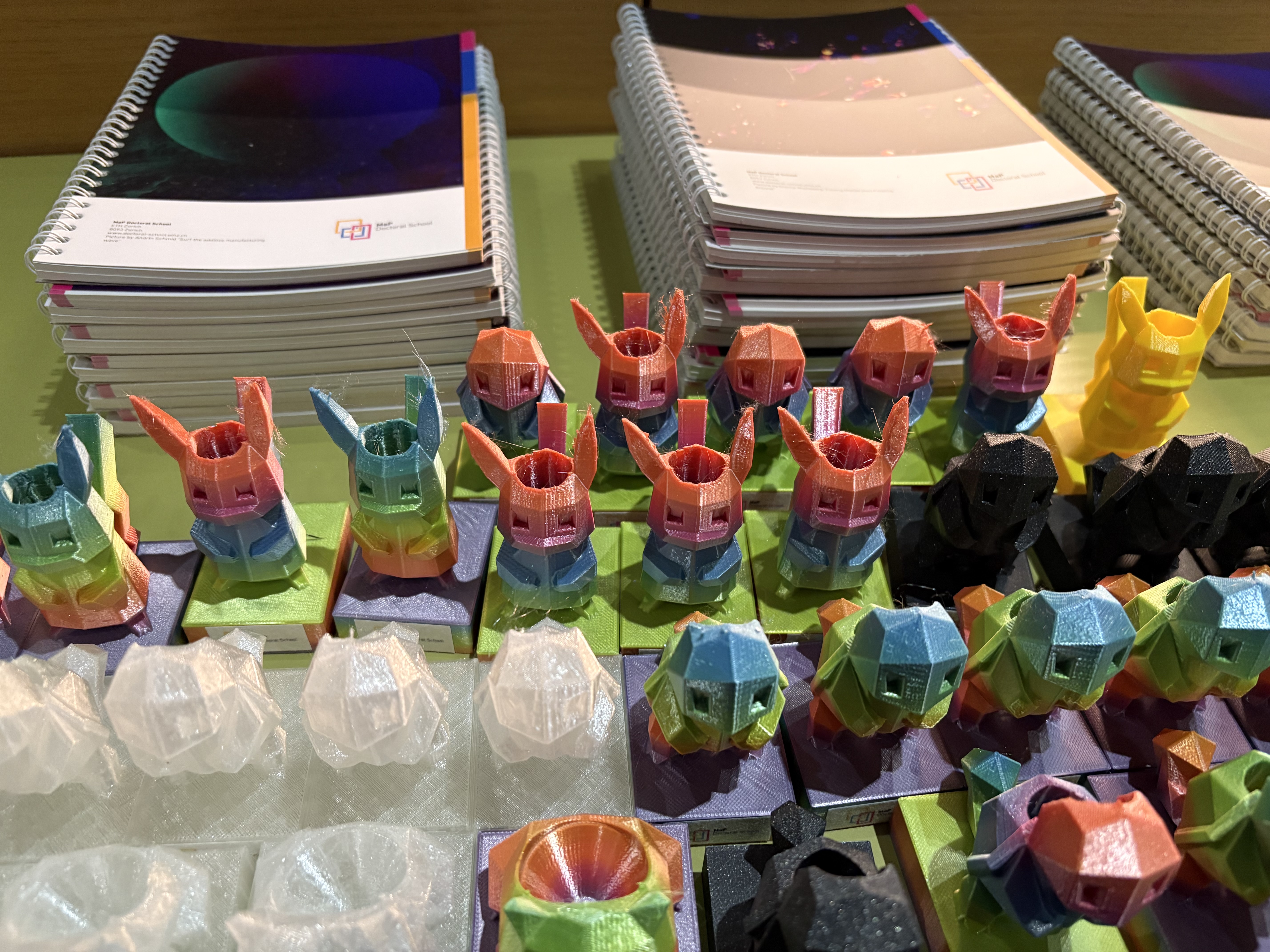 Two piles of lab books and four rows of 3D printed falcon tube holders