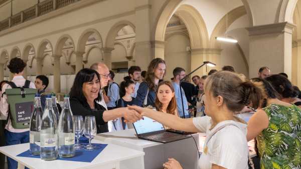 two women shaking hands at the registration desk